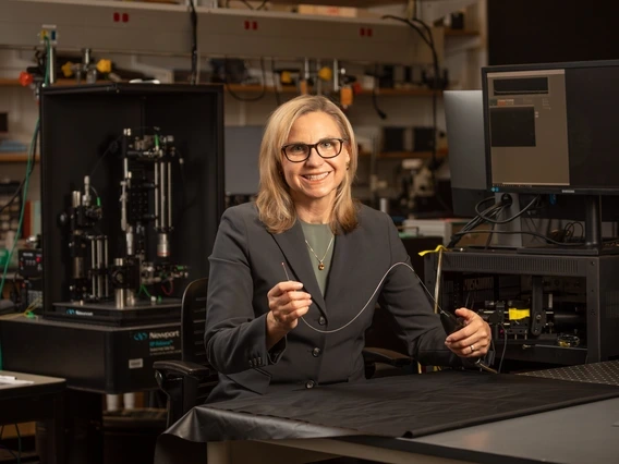 Jennifer Barton in a lab holding an ovarian cancer detection falloposcope