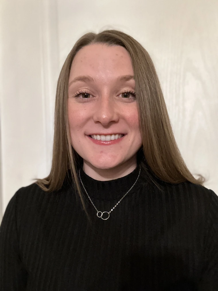 Smiling woman with long, brown hair in a black sweater