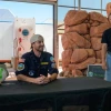 Matthias Beach sitting at a table and Kai Staats standing nearby, both smiling